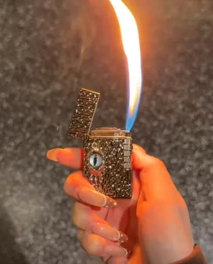Bật lửa đen Devil’s Eye cầm trên tay, họa tiết vảy nổi và chi tiết mắt
